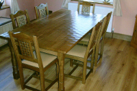 Oak table with adzed top. Carved lattice back chairs
