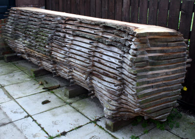 A 'tree' of cut wooden pieces stacked outside to be weathered